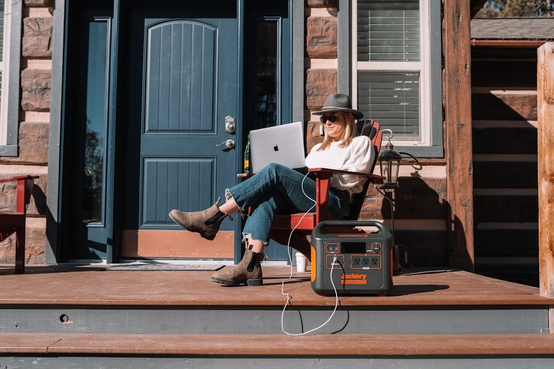 A portable power station in a natural outdoor setting, powering devices like a laptop and lights.