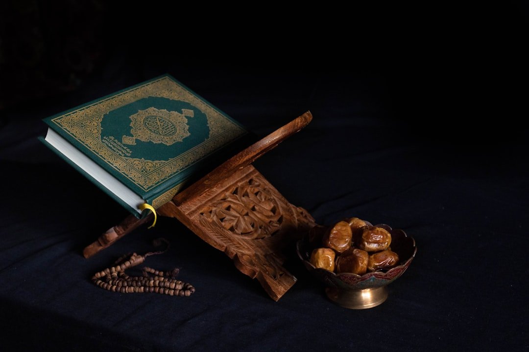 A collection of Islamic books and guides stacked on a wooden table, with a serene background that evokes a sense of spirituality and preparation.